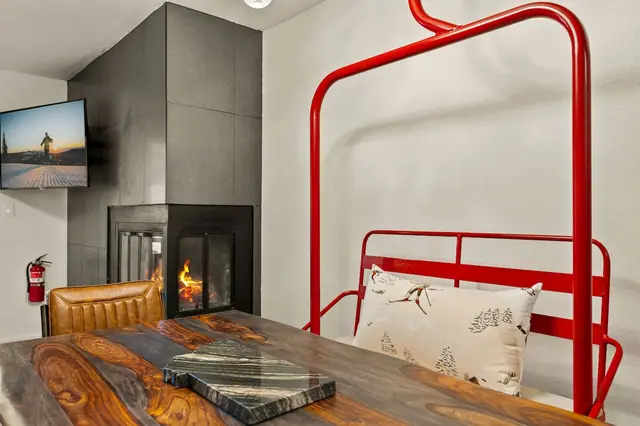 Look closer and you'll see it's a real retired chairlift chair turned into your dinner bench the fire and the TV keep going behind it while you eat.