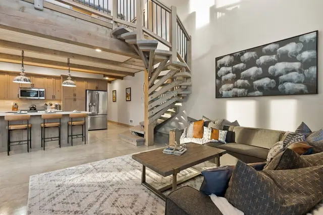 Claim your spot on the sectional under the big bison print and let the spiral staircase framing pull your eye up to the loft above.