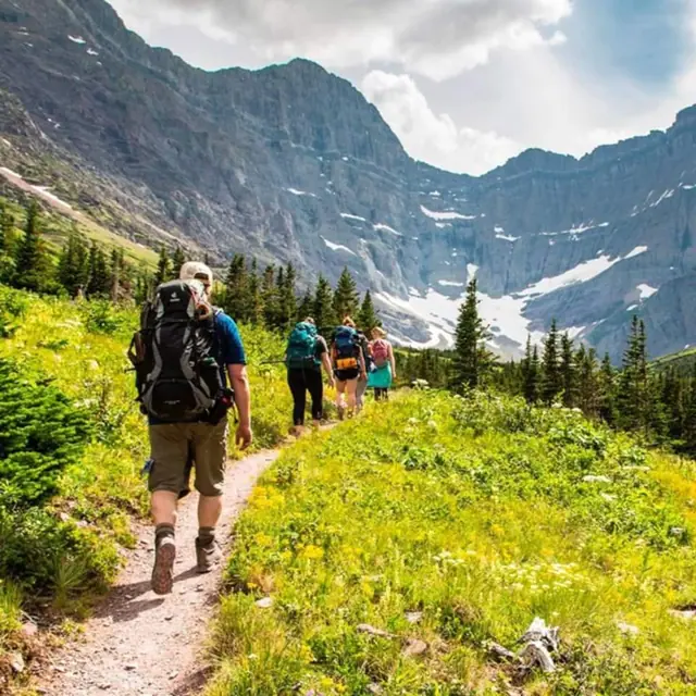 Generic stock-style photo of unidentified hikers, not taken at this property or verified to be Glacier NP. Replace with a real photo of the actual trailhead you recommend guests start from.