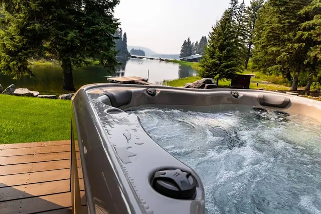 Sink into steaming water while the lake and mountains fade to purple behind you, this is your private hot tub at dusk.