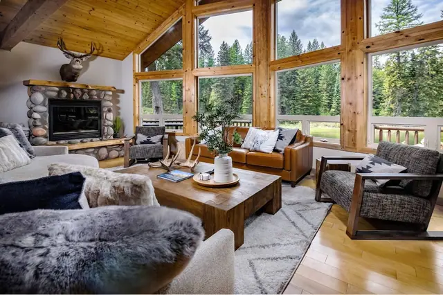 Curl up under a fur throw on the cream sectional as the stone fireplace and vaulted ceiling set the mood for you.