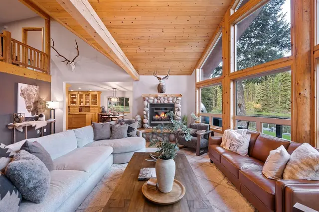 Stretch out across the white sectional and leather sofa while elk antlers watch over the fireplace above you.