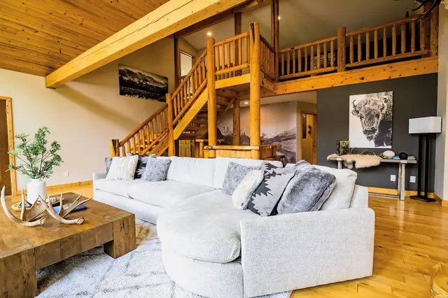 Head up your log staircase past framed mountain photography and a draped hide throw to the loft above.