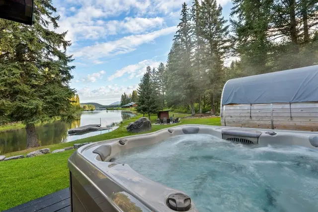 Feel the jets kick on as you sink into the hot tub, pond and treeline stretching out beyond the railing.