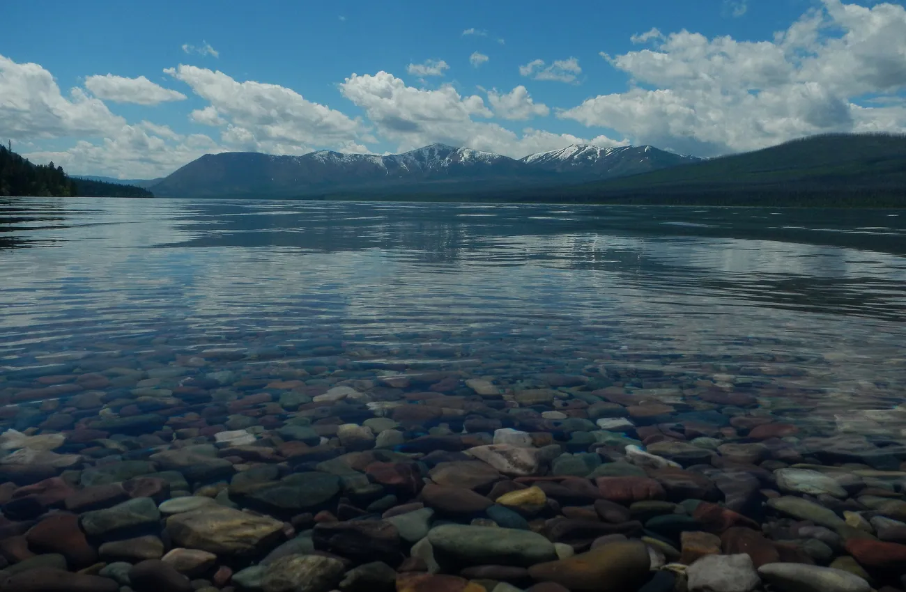 Coloured stones on the bed of Lake McDonald through clear water