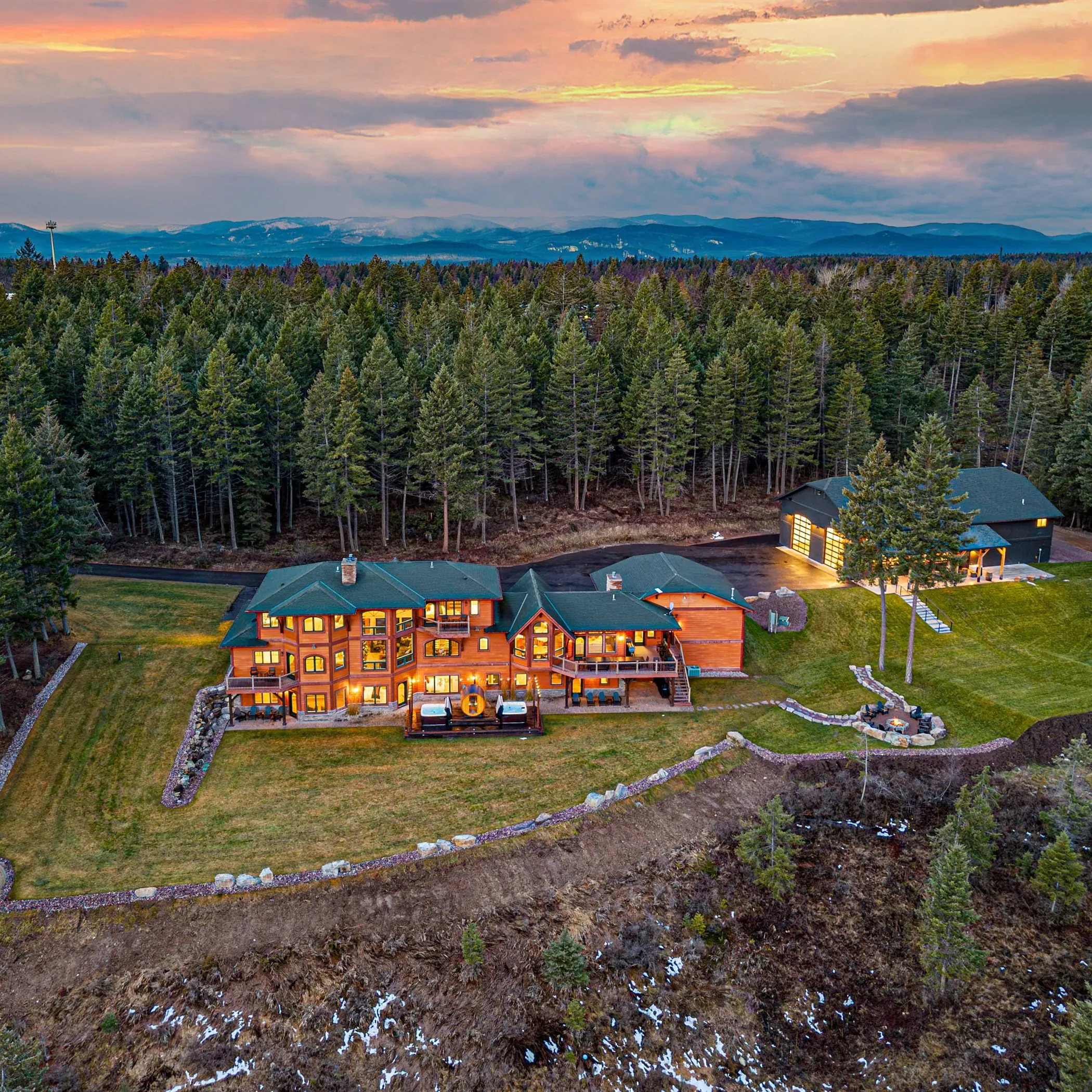 Soaring Eagle Lodge at dusk, the whole building lit from within above the lawn