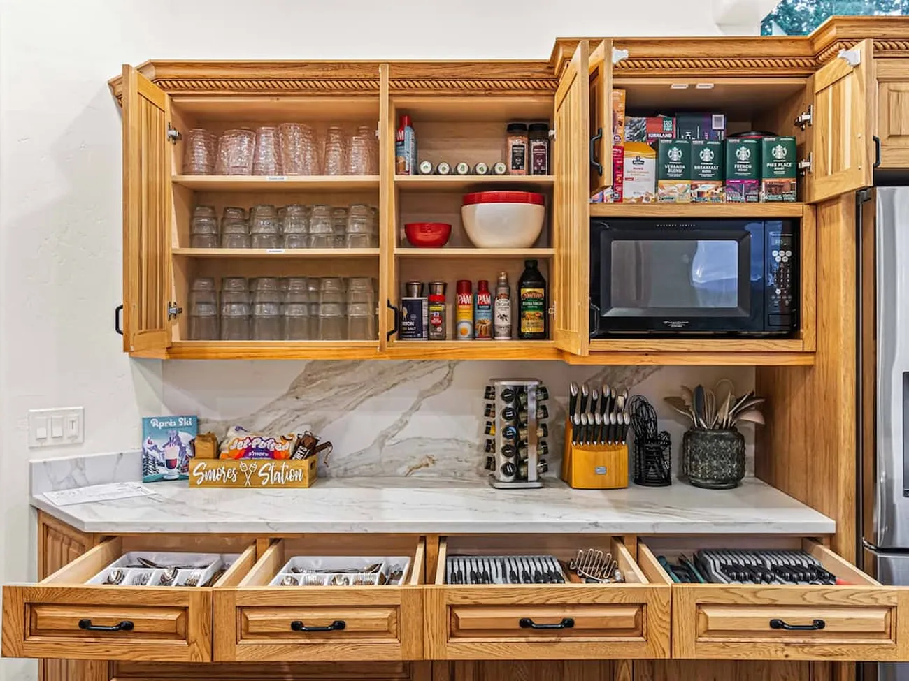 Kitchen cabinets and drawers open, everything stocked and in its place