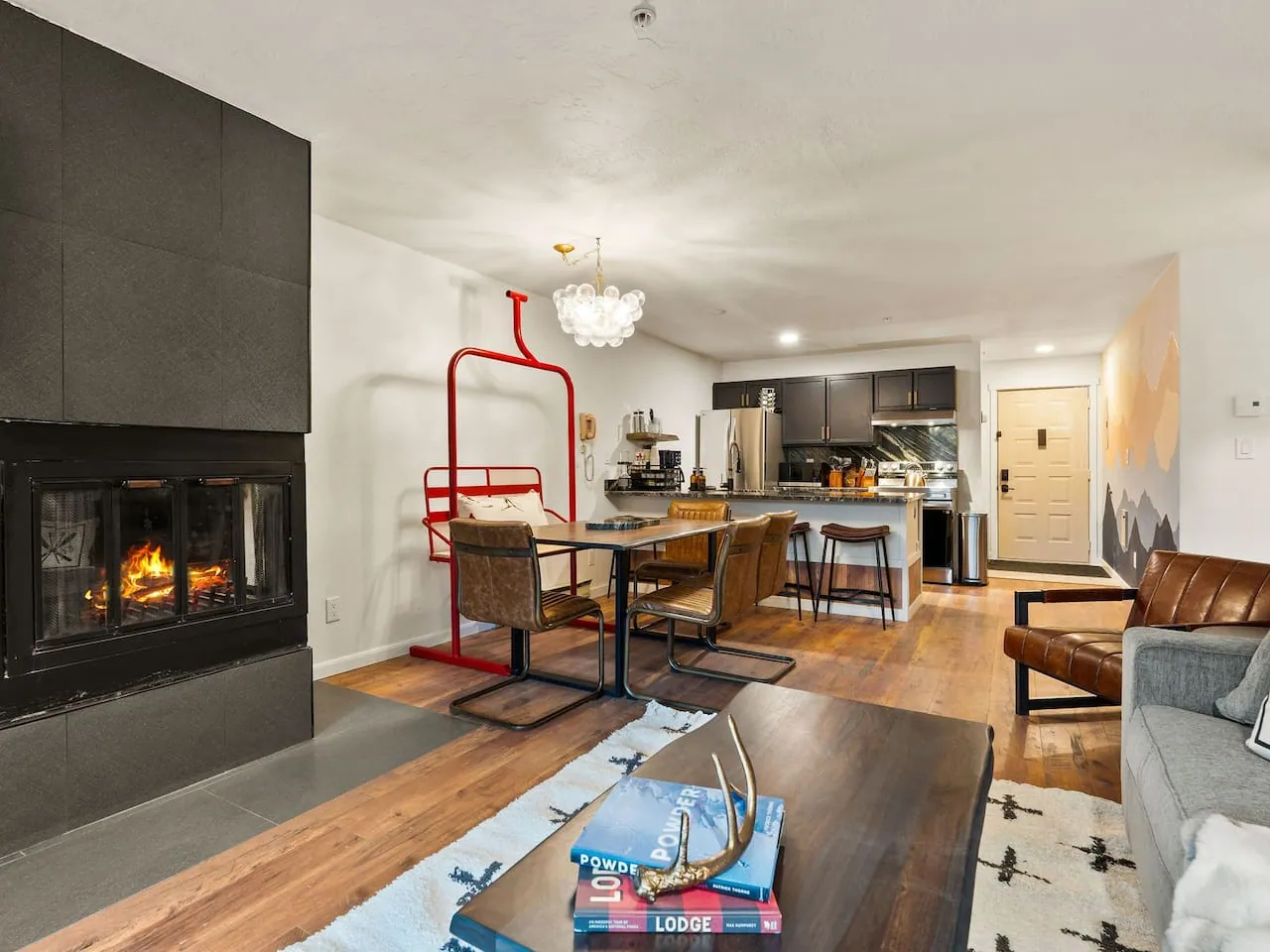The dining table at Chasing Powder with its retired chairlift bench, the fireplace and living room beyond