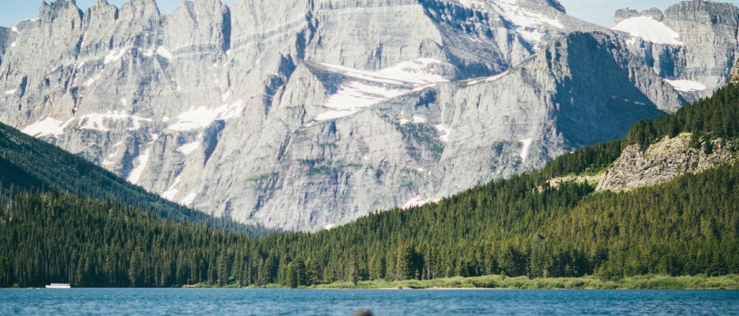 A kayaker crossing Swiftcurrent Lake below Mount Grinnell