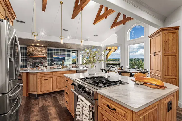 Gather your crew around the oversized island while the gas range and beam-lined vaulted ceiling turn cooking into a group event.