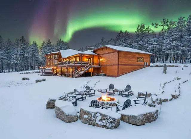 Catch the northern lights overhead while you circle the fire pit chairs on a snowy night.
