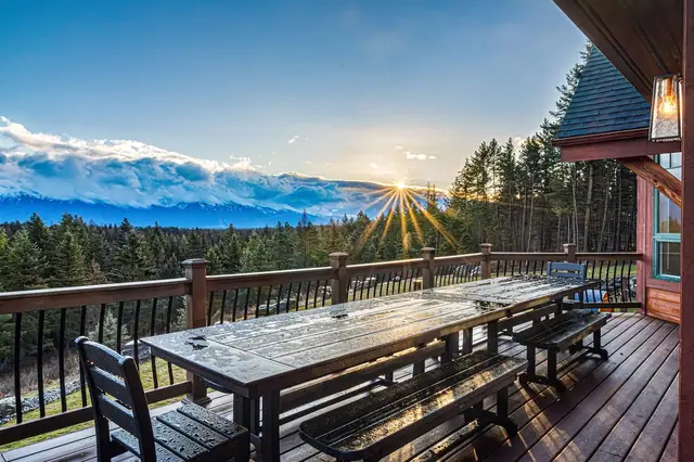 Set the long deck table before dinner and watch the sun break through the tree line behind the peaks.