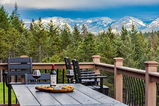 Sit down to wine and a charcuterie spread at the deck table, a wide-open view of the snowy peaks and forest just past your chair.