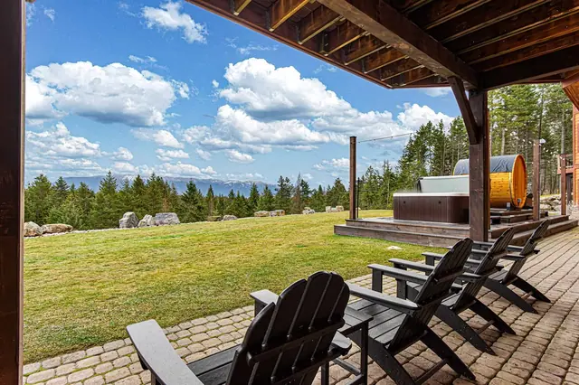 Take a seat on the covered patio overlooking the open field and boulders, with your hot tub peeking in at the edge of the view.
