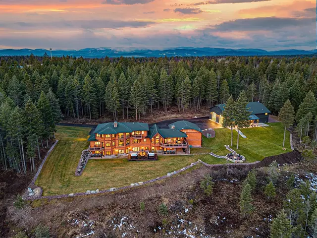 Spot both your main lodge and the separate event barn from the air, wrapped in forest under an orange sunset.