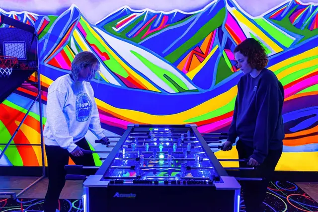 Face off at the foosball table while the rainbow mountain mural glows behind you under the blacklights.