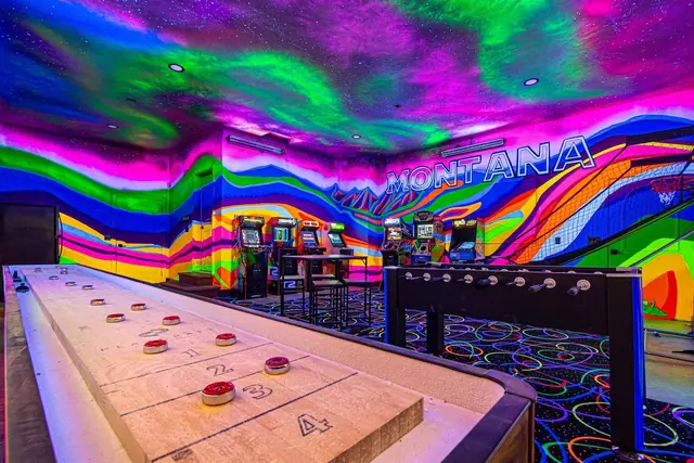 Slide the pucks down the shuffleboard table while the arcade hums in the background behind you.