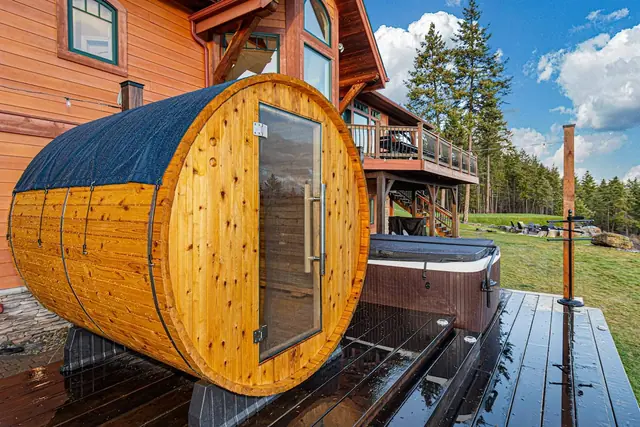 Step into your barrel sauna on the deck, just steps from the covered hot tub and the lawn beyond