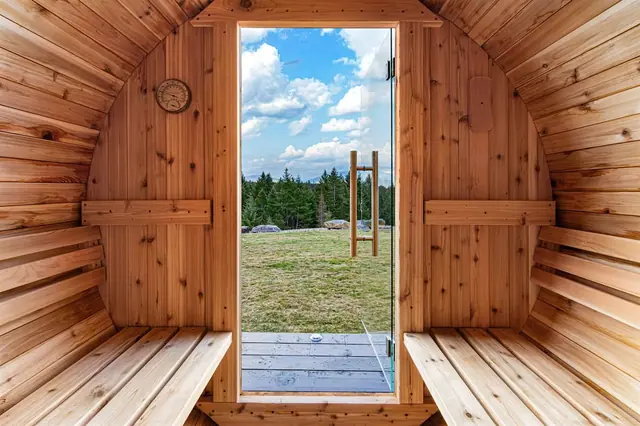 Crack the sauna door open to the grassy field and evergreens while you let the heat build on the curved benches.
