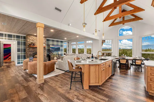 Take in your whole great room at once fireplace, kitchen island, and dining table under one vaulted, arched-window ceiling.