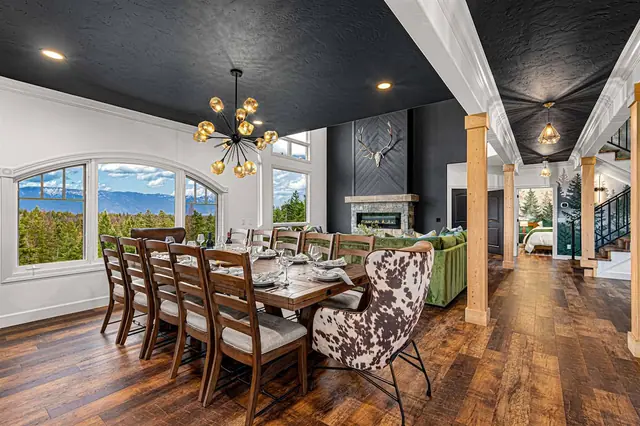 Seat your whole group at the dining table under the sputnik chandelier, stone fireplace and mountain view close by.