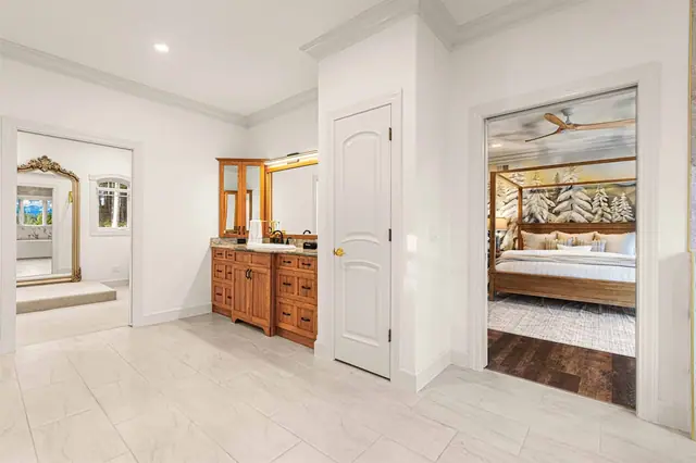 Pass between the vanity and the canopy bedroom along this connecting hallway inside the suite.