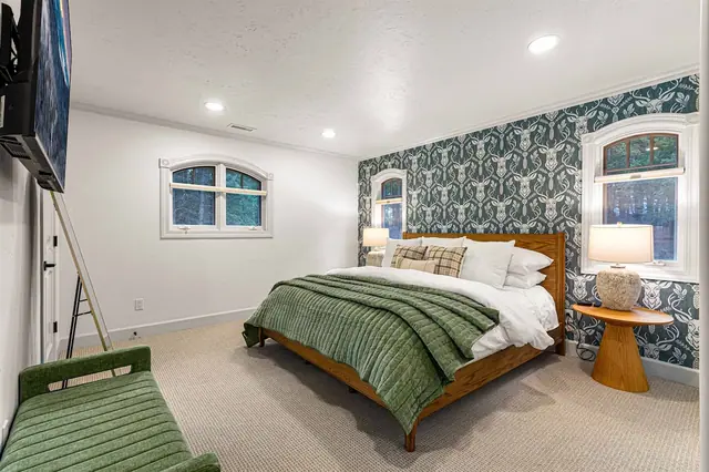 Wake to a forest view through your arched window in the Pine Room, mirror and hallway just past the open door.