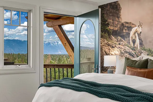 Push open the arched glass door onto your own balcony beneath a mountain-goat cliff mural.