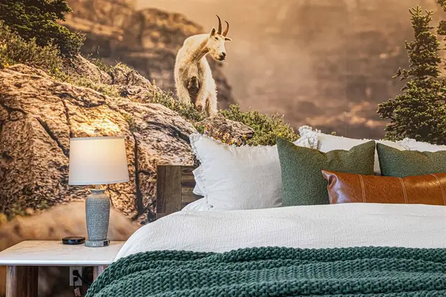 Nestle into the pillows at the headboard while the mountain-goat mural climbs the wall above you.