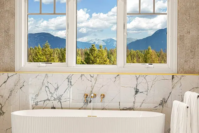 Fill the tub from the gold-tone filler while the three-pane window frames the mountain range in front of you.
