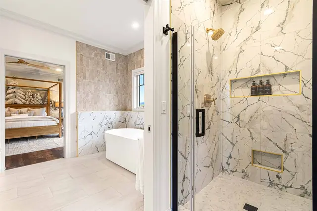 Step into your walk-in shower and reach the toiletries right from the gold-trimmed niche shelves.