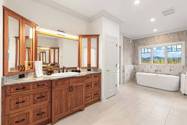 Share the double-sink vanity while you catch a glimpse of the soaking tub and mountain view through the doorway.