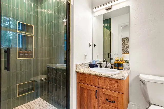 Get ready at the vanity mirror before ducking into your tiled shower stall next door.
