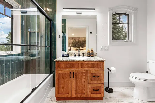Draw a bath behind the glass door while the mirror reflects the mountain-goat mural in the bedroom beyond.
