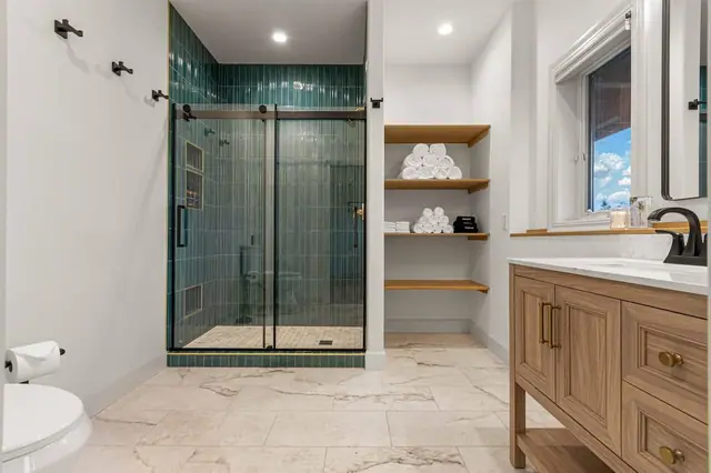 Grab a fresh towel from the floating shelves on your way into the glass-enclosed shower.