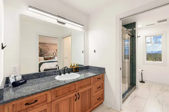 Wash up at the granite vanity while the mirror catches the mountain-goat mural from the bedroom next door.