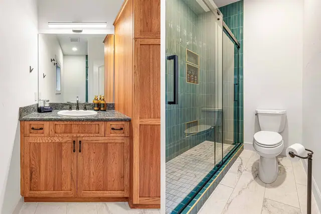 Split your morning routine between the vanity mirror and the glass shower stall in this ensuite.