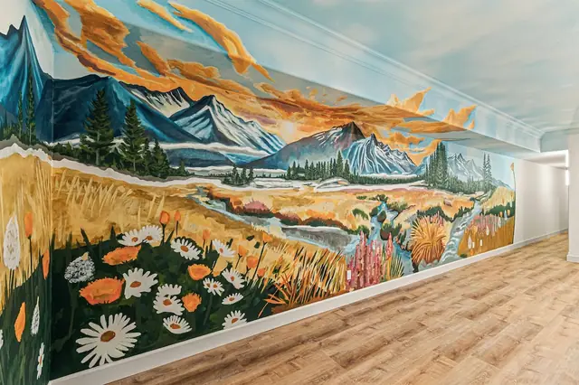 Walk the length of the hand-painted mural hallway, sunrise sky and wildflower fields stretching the full wall.